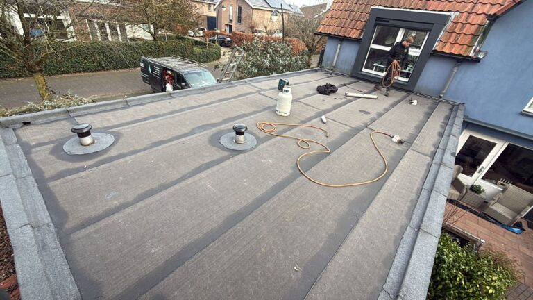 Wortelwerende bitumen dakbedekking aangebracht op een plat dak tijdens een dakrenovatie in Amersfoort.