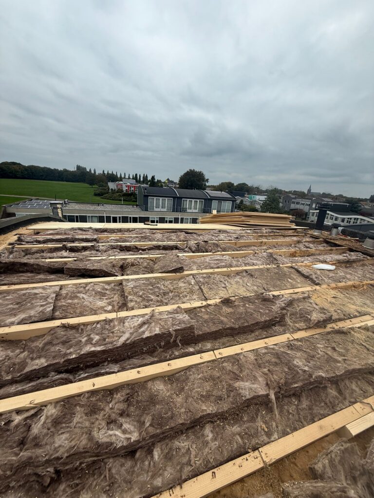 Dakrenovatie in Amersfoort met nieuwe dakbalken, isolatie, underlayment en afgewerkt met duurzame bitumen dakbedekking.