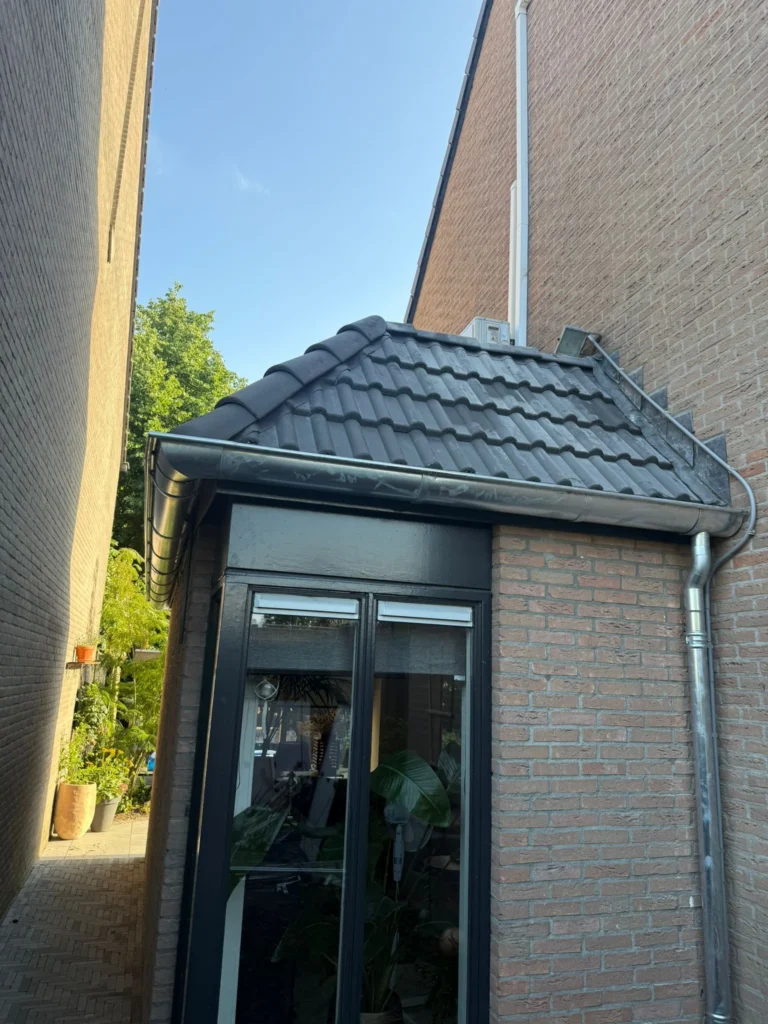 Dakrenovatie in Spakenburg met vernieuwd pannendak, zinkwerk op het platte dak, dakkapel en vernieuwde dakgoten.